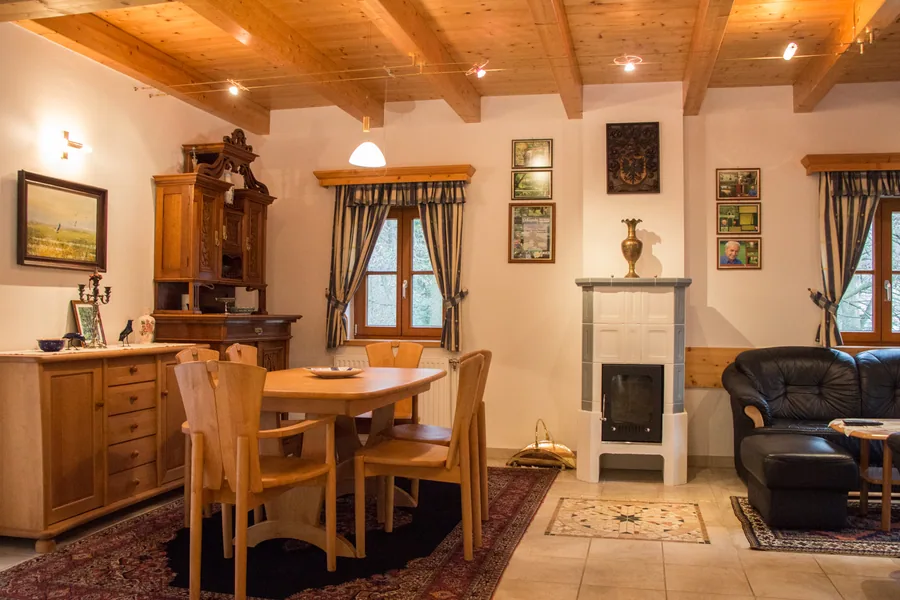 Wohn- und Esszimmer im Gästehaus mit Holzbalkendecke und Kachelofen
