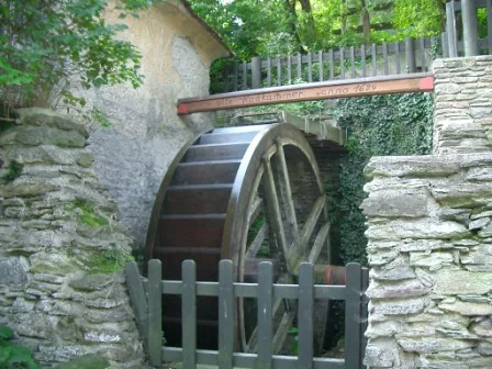Das hölzerne Mühlrad zwischen Steinmauern